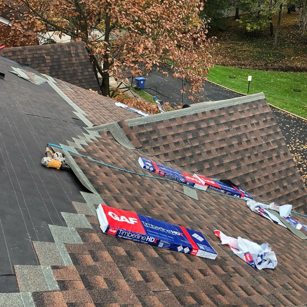 GAF Timberline HDZ shingle bundles on a roof as new brown shingles are installed