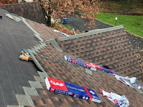 GAF Timberline HDZ shingle bundles on a roof as new brown shingles are installed