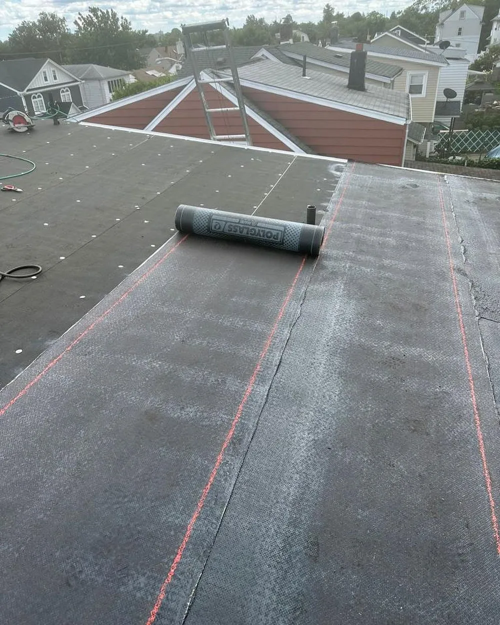 New torch-down roofing being rolled out across a flat roof