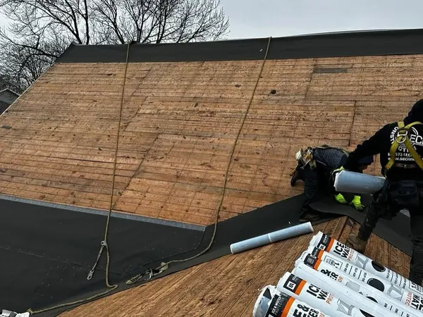 Rolls of ice and water shield membrane on old plank decking during a roof replacement