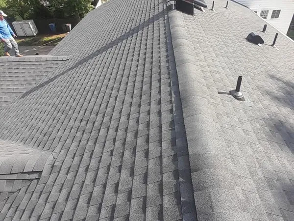 New gray shingle roof with ridge caps, pipe boots, and roof vents along the ridge
