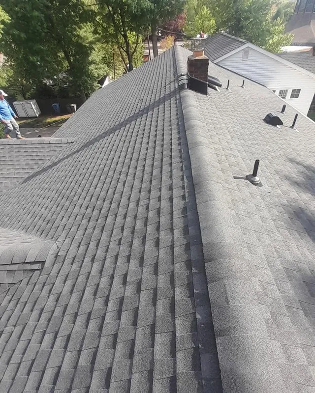 New gray shingle roof with ridge caps, pipe boots, and roof vents along the ridge