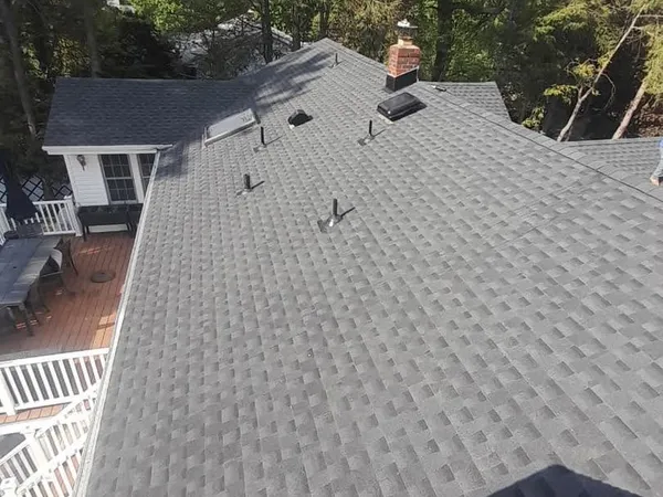 New gray shingle roof seen from above, covering the whole house with a deck and back yard below
