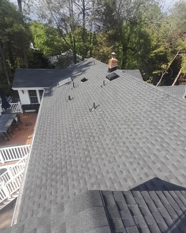 New gray shingle roof seen from above, covering the whole house with a deck and back yard below