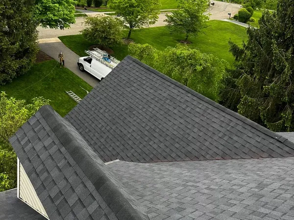 New gray shingle roof with a gable dormer, overlooking a green suburban neighborhood