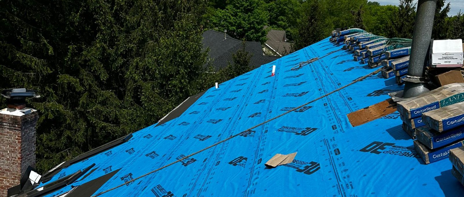 Roof leak repair in New Jersey by All Pro 1 technician inspecting a residential roof